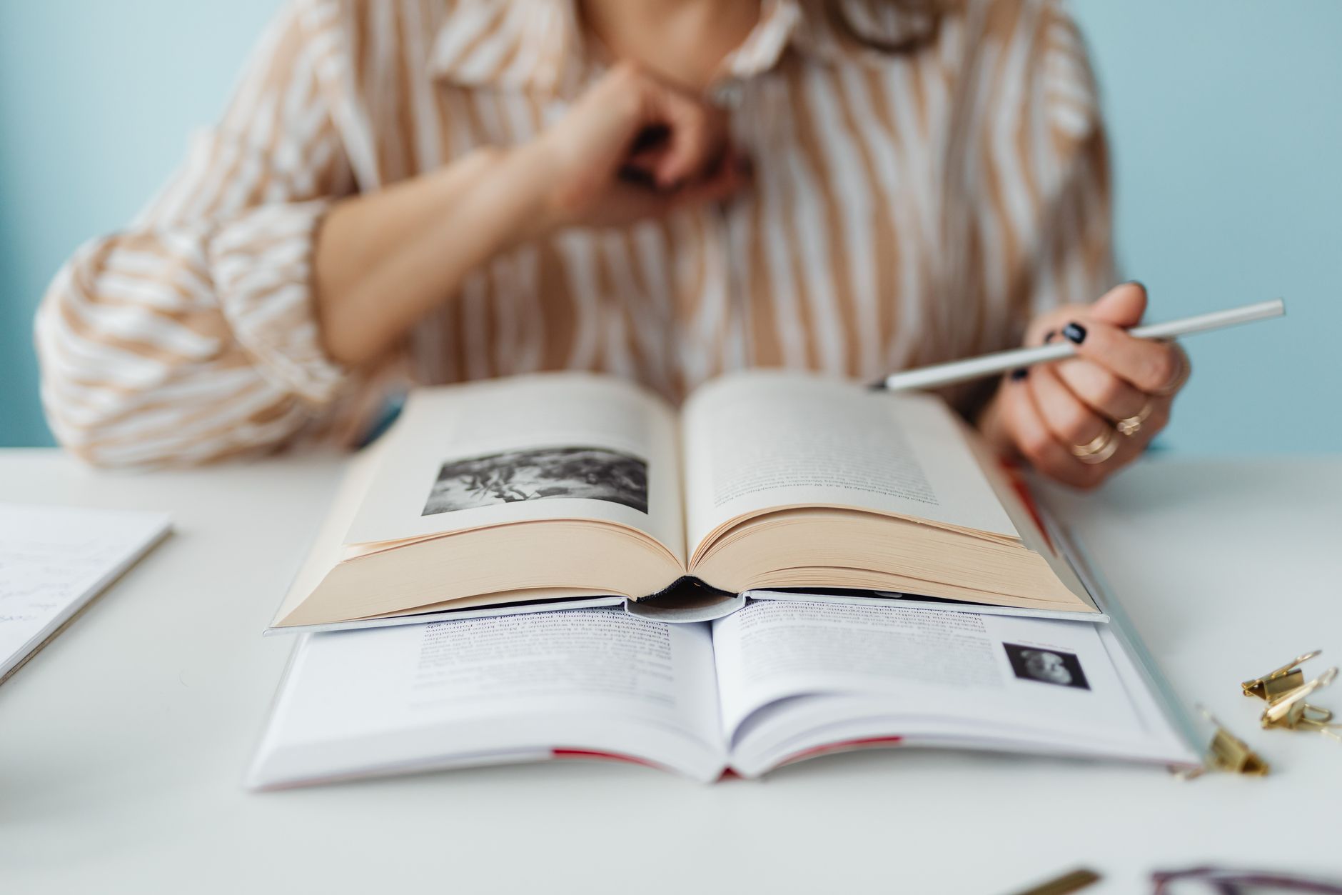 a woman sitting at the table reading a book
